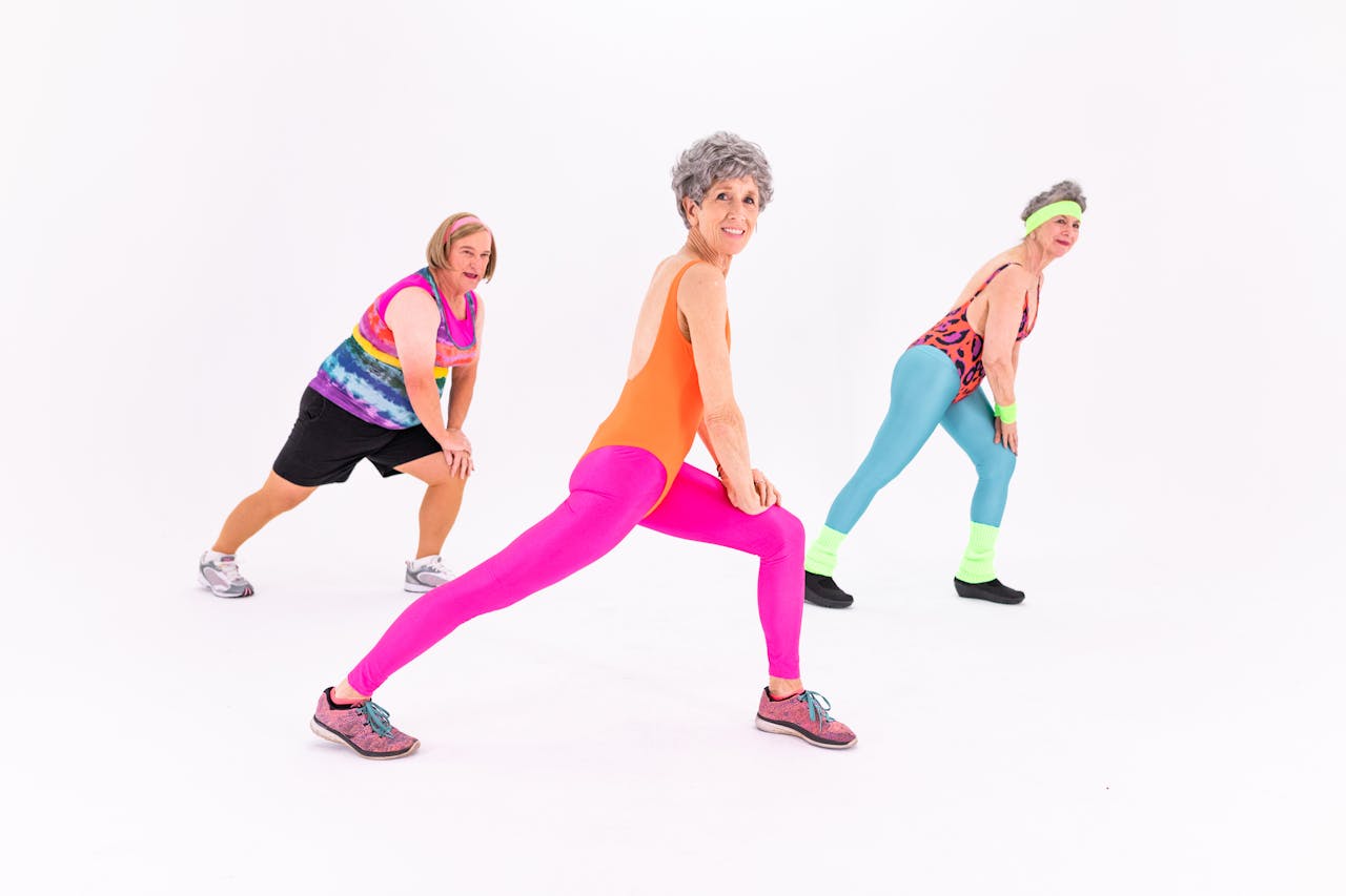 Senior women having fun while exercising in colorful activewear, promoting healthy lifestyles.
