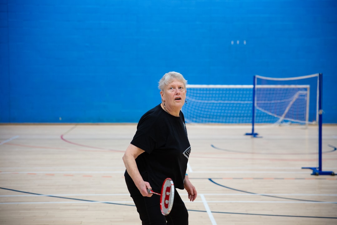 elderly-woman-playing-badminton-in-a-gymnasium-7dgov3pejc4